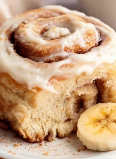 Freshly baked banana bread cinnamon rolls drizzled with icing