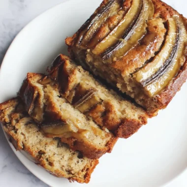 Loaf of classic banana bread sliced on a wooden cutting board
