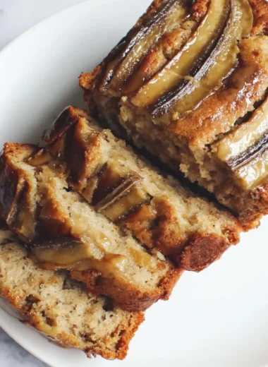 Loaf of classic banana bread sliced on a wooden cutting board