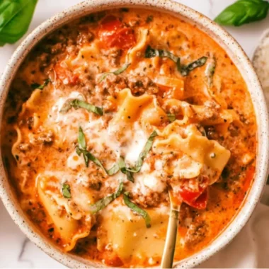 Bowl of creamy lasagna soup topped with cheese and herbs