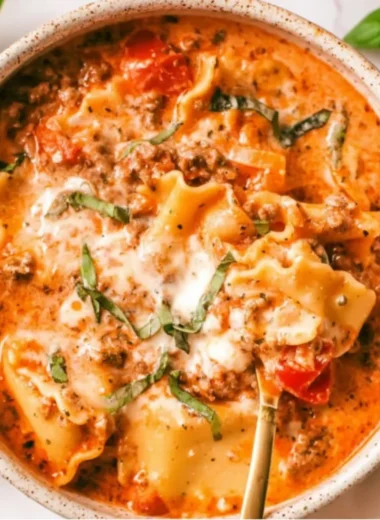 Bowl of creamy lasagna soup topped with cheese and herbs