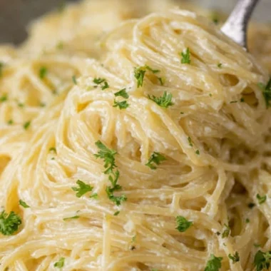 A bowl of creamy Garlic Parmesan Pasta garnished with parsley and grated cheese