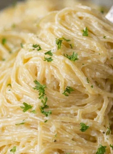 A bowl of creamy Garlic Parmesan Pasta garnished with parsley and grated cheese