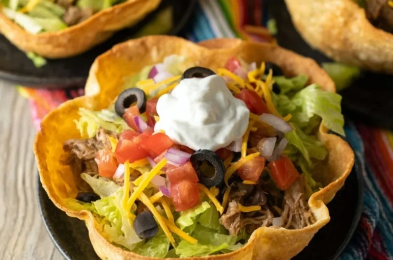 Colorful taco salad bowl with fresh vegetables and toppings
