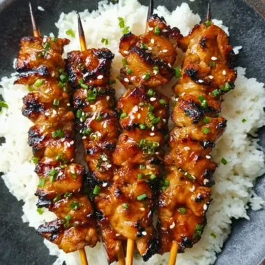 Grilled teriyaki chicken skewers with vegetables on a platter