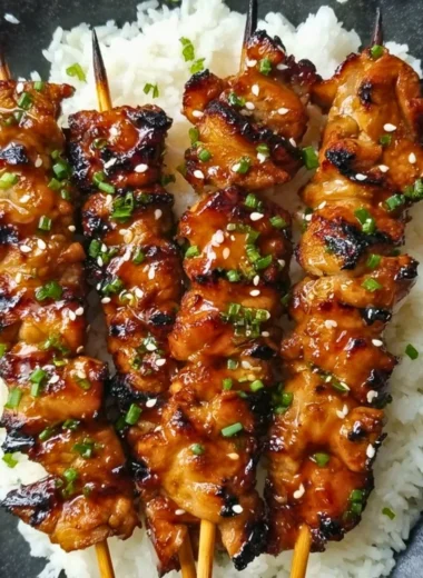 Grilled teriyaki chicken skewers with vegetables on a platter