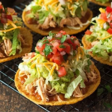 Delicious Chicken Tostadas topped with guacamole and beans on a plate