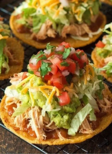 Delicious Chicken Tostadas topped with guacamole and beans on a plate