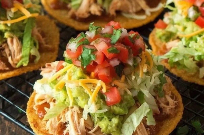 Delicious Chicken Tostadas topped with guacamole and beans on a plate