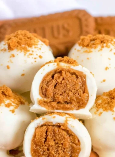 Homemade Biscoff truffles on a plate sprinkled with crushed Biscoff cookies.